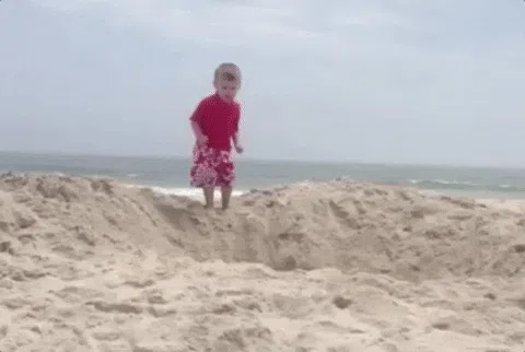 孩子在沙滩上小小地跳水