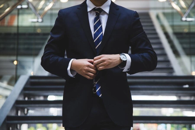 一位身着帅气西装的男子正走下楼梯。