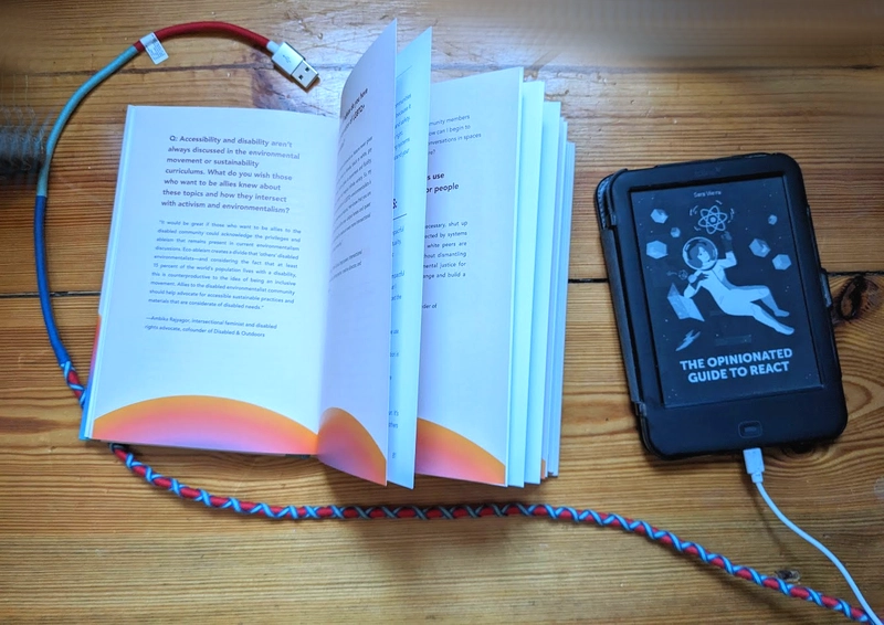 纸质书和较小的灰度电子书阅读器都连接着电源线。