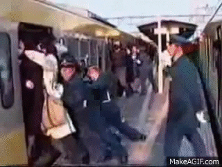车站工作人员将人们推入拥挤的火车